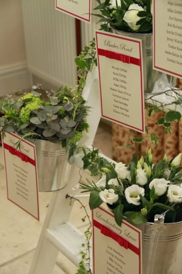 Alternative wedding table plan cards on flower pots suspended from a ladder