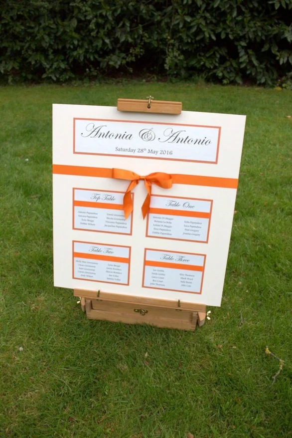 Vibrant bright orange wedding table plan mounted on cream ivory small 4 tables