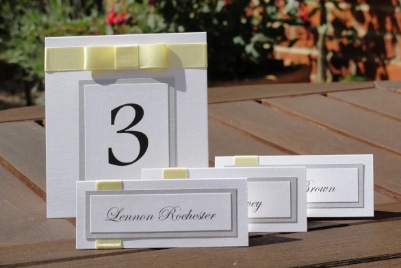Wedding table numbers and place cards made in white, silver and pale lemon yellow